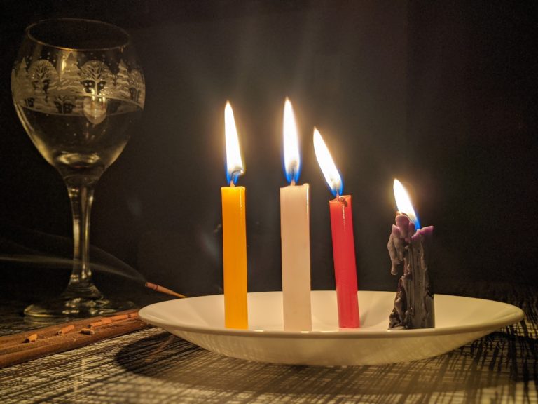 black candle with red, white, and yellow candles