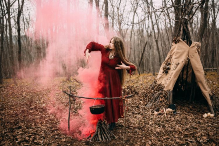 woman in the woods dancing in red smoke