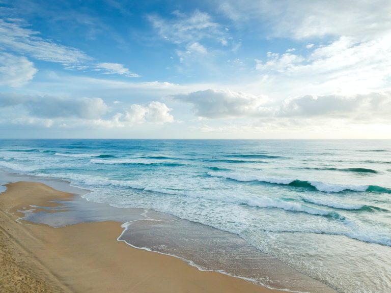 ocean water washing up on a sandy beach