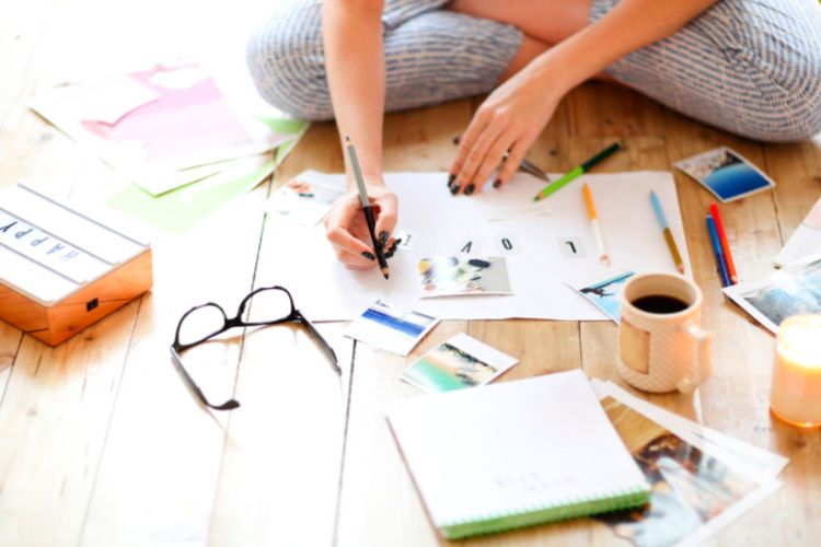 girl with papers and pens on wooden floor