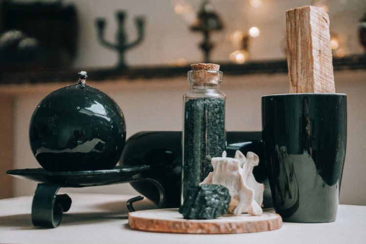 altar with black witchy tools including a crystal ball, spell jar, and cup