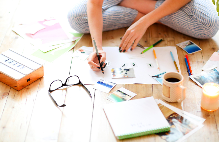 girl making a vision board for love on a wooden floor