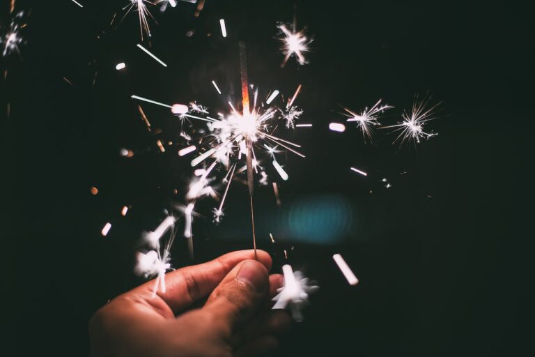 hand holding a new year sparkler on a dark background