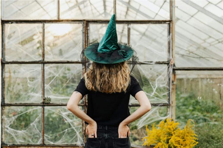garden witch in a greenhouse with back facing to camera